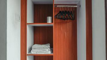 A wooden wardrobe with shelves and a hanging rod.
