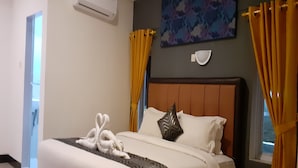 A neatly made bed with white linens, a brown headboard, and decorative pillows. - New Hotel Gentala (Medan)