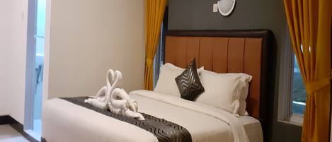 A neatly made bed with white linens, a brown headboard, and decorative pillows.