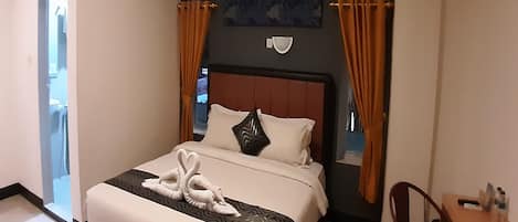 Una habitación de hotel con una cama, un escritorio y una silla.