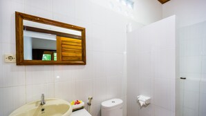 Ein Badezimmer mit Waschbecken, Spiegel, Toilette und Dusche.
