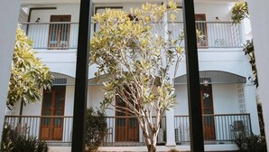 A two-story building with a balcony on the upper floor, surrounded by greenery. - Baan Chiang Bed Lampang (Lampang)