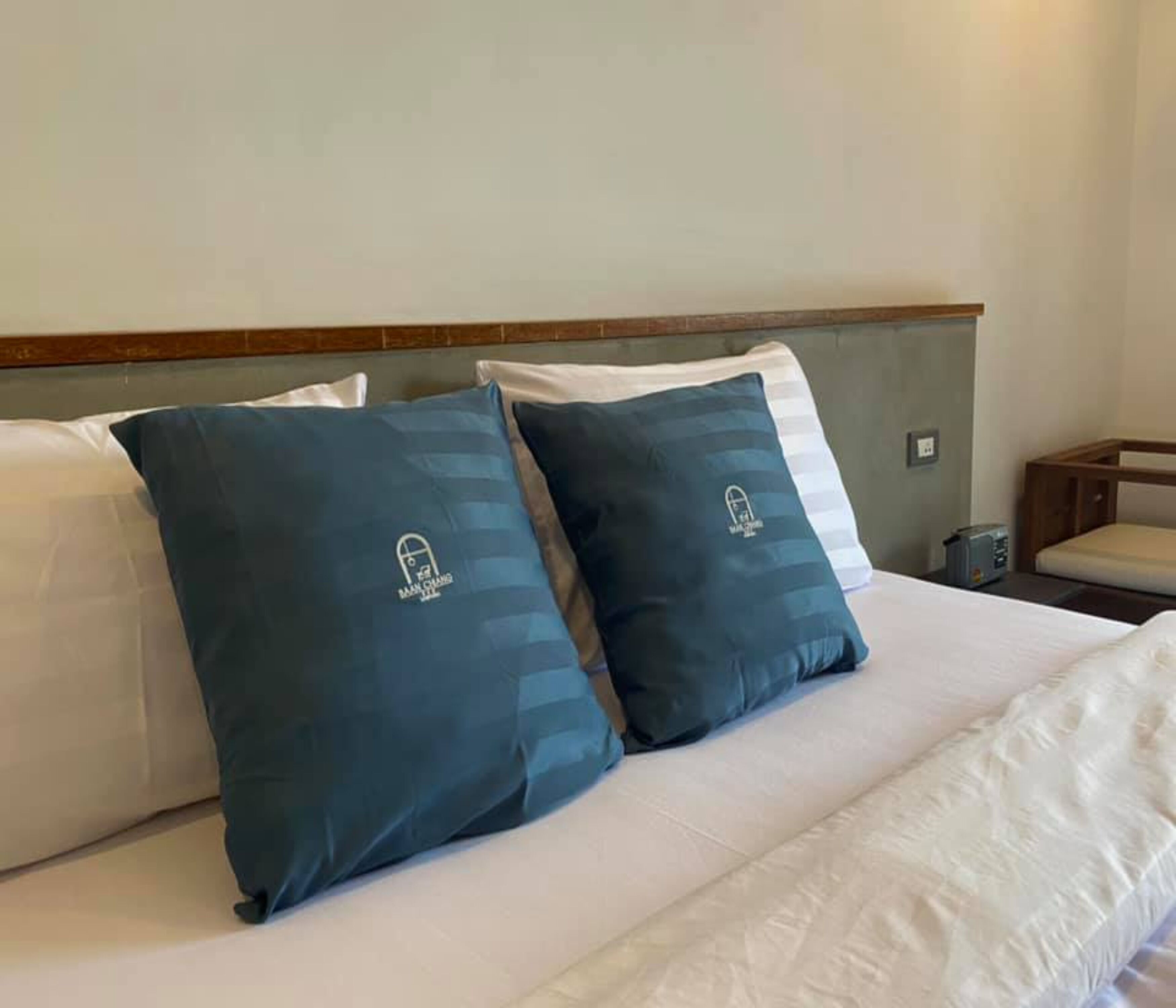 A bed with two pillows and a wooden headboard.
