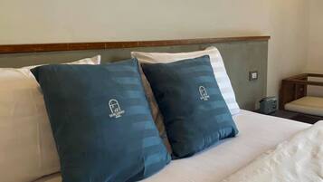 A bed with two pillows and a wooden headboard.