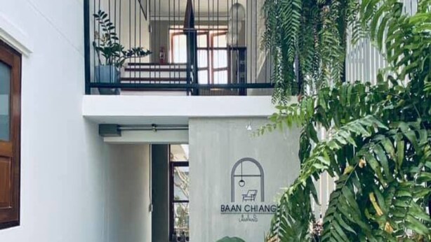 A modern building entrance with a sign for 'BAAN CHANG' and a balcony with metal railings. - Baan Chiang Bed Lampang (Lampang)