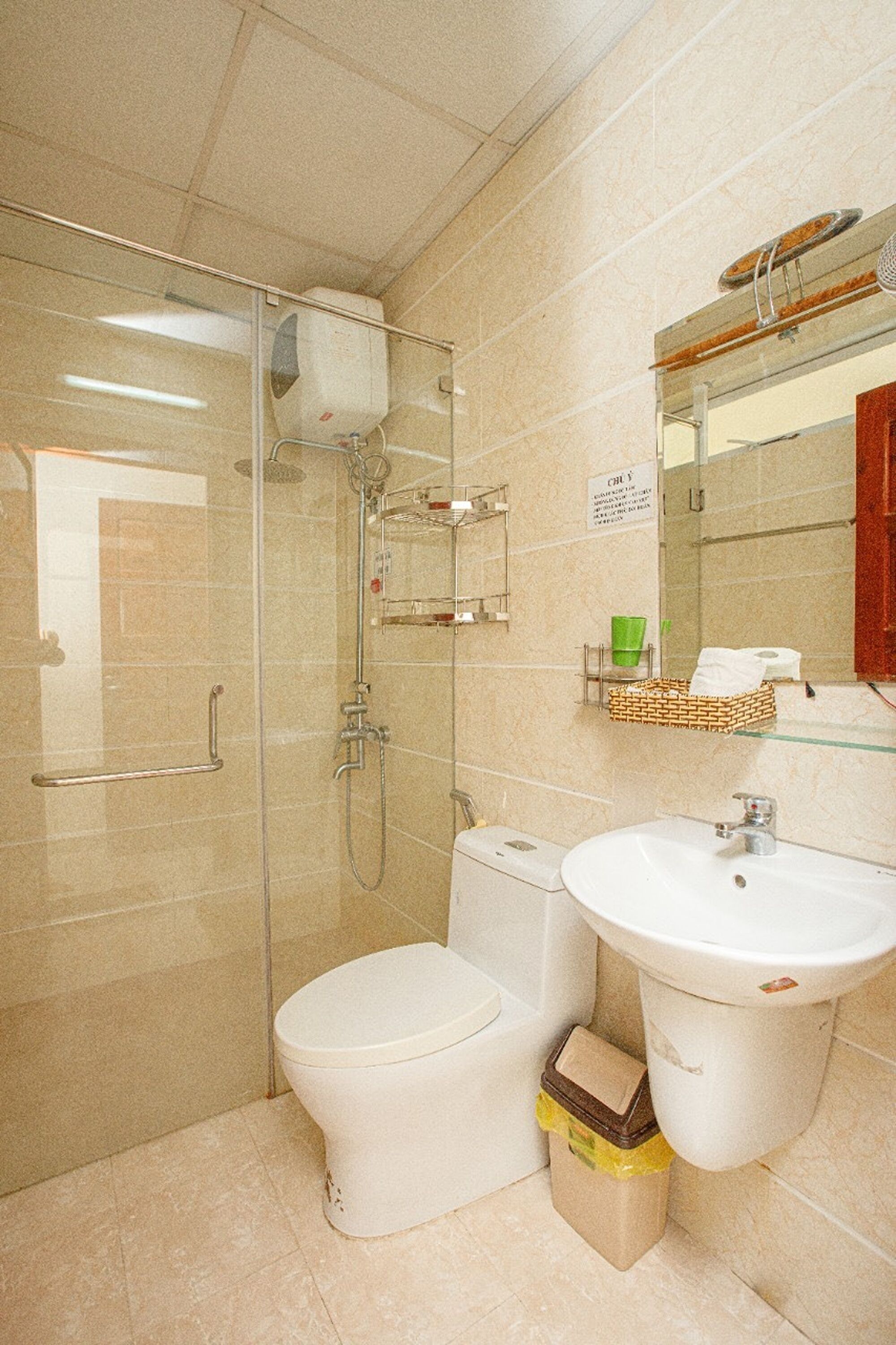 A bathroom with a glass-enclosed shower, a toilet, and a sink.