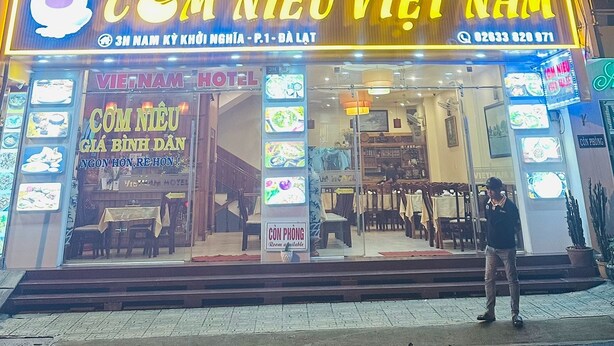 A building with a sign for "VIET NAM HOTEL" and "COM NIEU VIET NAM" restaurant.