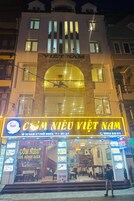 A building with a sign for "VIET NAM HOTEL" and "COM NIEU VIET NAM" restaurant.