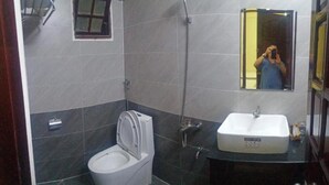Une salle de bain avec des toilettes, un lavabo et un miroir.