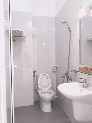 Une salle de bain moderne équipée de toilettes, d’un bidet et d’un lavabo.