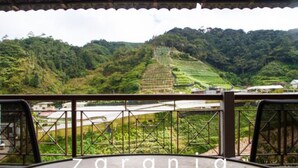 A view from a covered terrace overlooking terraced fields and a distant village. - Zarania Hillhomes Cameron Highlands (Brinchang)