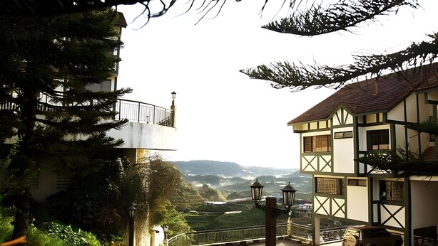 A traditional building with a balcony, a view of the countryside, and a parked vehicle. - Zarania Hillhomes Cameron Highlands (Brinchang)