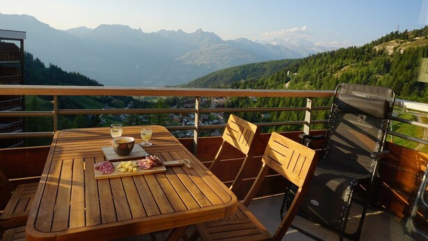 A wooden table with a view of mountains, a chair, and a bench on a balcony. - 6 pers- plagne center, Montblanc view, telebus base. (LA PLAGNE)