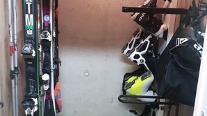 A narrow hallway with skis and ski equipment on racks. - 6 pers- plagne center, Montblanc view, telebus base. (LA PLAGNE)