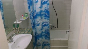 Een badkamer met een wastafel, een douchegordijn met een dolfijnenprint en een bad.