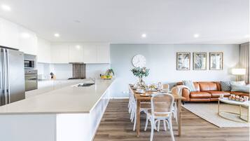 Una cocina moderna con armarios blancos, una isla central y electrodomésticos de acero inoxidable.