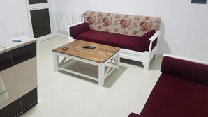 Ein Wohnzimmer mit einer Couch, einem Couchtisch und einem roten Sessel.