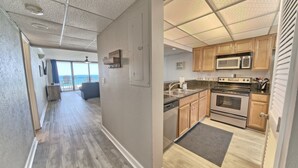 Una cocina moderna con armarios de madera, electrodomésticos de acero inoxidable y vistas al exterior.
