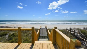 A wooden staircase leading to a beach with a clear sky and ocean view. - Majestic View: Luxurious 8-bedroom oceanfront home in North Topsail Beach for up to 30 guests. (North Topsail Beach)