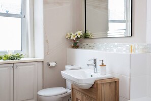Une salle de bain avec des toilettes, un lavabo et un miroir.
