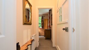 A narrow hallway with a wooden bench, a radiator, and a black rug. - Nursery Cottage - Benmore -  woodland setting, sleeps 4 guests (Benmore, Dunoon)