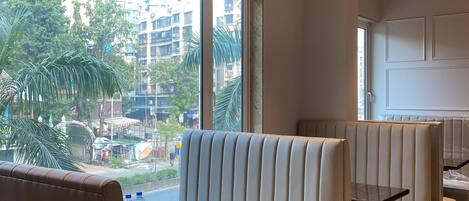 A modern restaurant with high-backed booths, a glass table, and an air conditioning unit.