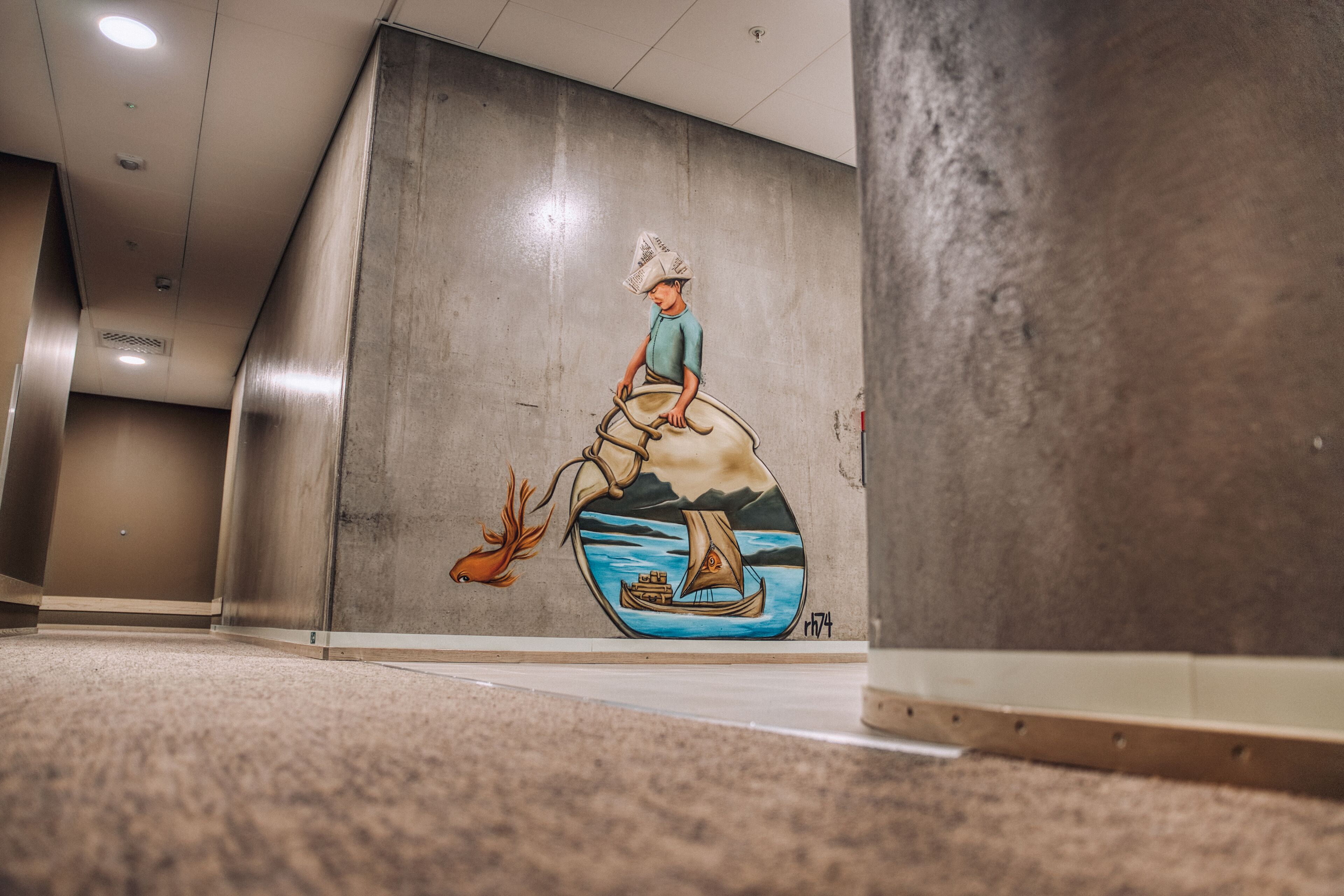Et mural viser en person i en båd med en hjort på en væg i en gang.