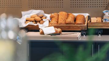 A buffet setup with various breads and pastries.