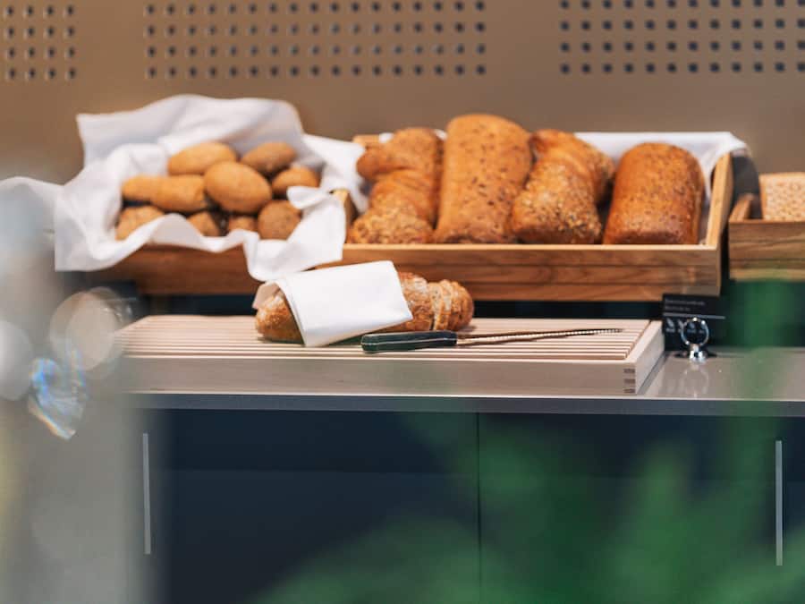 A buffet setup with various breads and pastries.