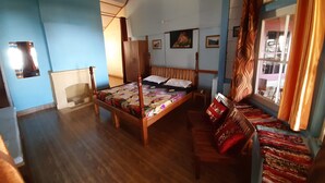 A room with a wooden bed, a wooden bench, a wardrobe, and a window with curtains.