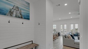 A modern interior with a bench, a sofa, and a dining area with chairs. - GULF PLACE-STUNNING CONDO OFF 30A!! 3 BED/3 BATH!! SLEEPS 6!! (Santa Rosa Beach)