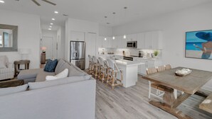 A modern kitchen with white cabinets, a stainless steel refrigerator, and a central island with bar stools. - GULF PLACE-STUNNING CONDO OFF 30A!! 3 BED/3 BATH!! SLEEPS 6!! (Santa Rosa Beach)