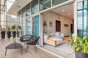 Un espace de vie moderne comprenant un canapé, des fauteuils, une table basse et des plantes en pot.