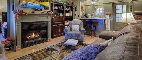 A living room with a fireplace, a television mounted above it, a sofa, and a coffee table.
