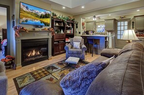 A living room with a fireplace, a television mounted above it, a sofa, and a coffee table.