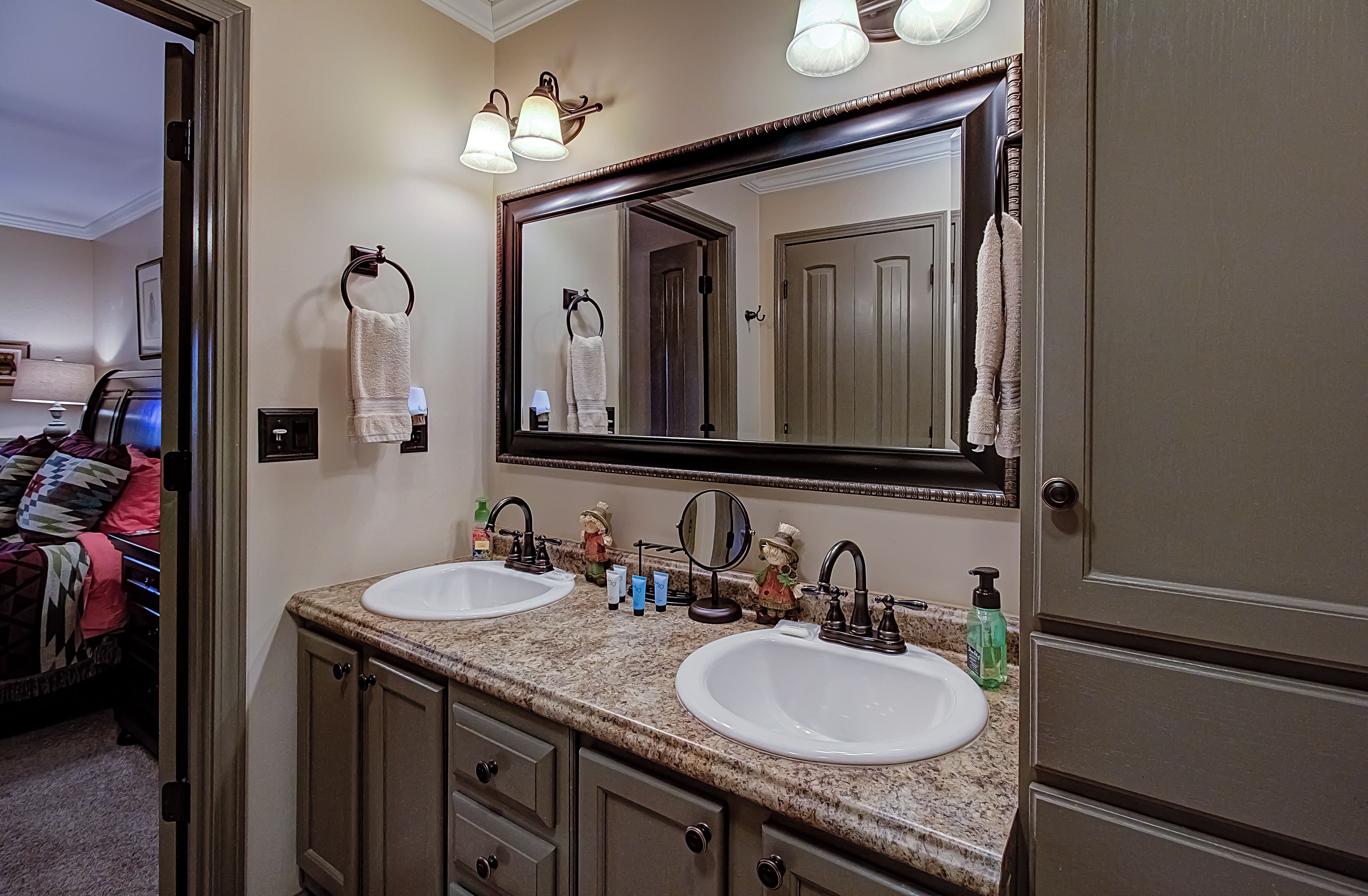 A bathroom with two sinks, a large mirror, and a towel rack.