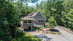 A two-story house with a porch, a garage, and a flag.