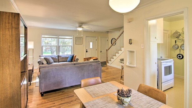 A spacious living area with a sofa, dining table, and a kitchen in the background. - Mid-Century Bozeman Townhome ~ 1 Mi to Dtwn! (Bozeman)