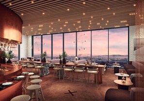 Un interior moderno con ventanas amplias, una zona de bar y diferentes disposiciones de asientos.