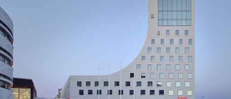A modern building with a curved facade, multiple windows, and a Scandic sign.