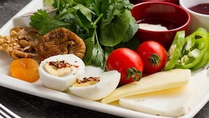 A plate with various food items including cheese, tomatoes, and herbs. - Özhan Hotel (Antakya)