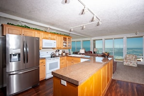 Enjoy cooking and dining with a scenic ocean view from this kitchen, featuring a large island and modern appliances.
