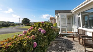 A residential property with a garden, a white house, and a clear blue sky. - 33 Weymouth Park (Kingsbridge)