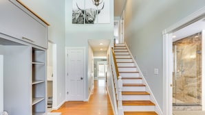A hallway with a wooden staircase, a closet with shelves, and a shower area. - 1 Mi to Okemo Mtn Resort: Ludlow Home w/ Hot Tub (Ludlow)