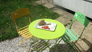 A small outdoor table with a green tablecloth, two chairs, and a plate with bread and tomatoes. - 4-PERSON STUDIO AT THE FOOT OF THE NORDIC SKI SLOPES (BESSANS)
