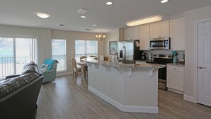 A modern kitchen with white cabinets, stainless steel appliances, and a large island. - Top Floor, Corner Unit Gulf Front Condo in MXB - Views All Around Surfside 16 (Mexico Beach)