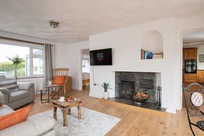 A living room with a fireplace, a television mounted on the wall, and a sofa.
