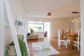 Dining room opening into the conservatory, charming single-storey holiday bungalow in Rhosneigr, Anglesey