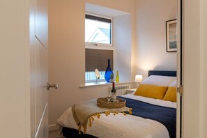 Second double bedroom with warm mustard coastal styling, pet-friendly holiday apartment two minutes from the beach in Rhosneigr, Anglesey - Sea Breeze: Three bedroom holiday apartment in Rhosneigr (Rhosneigr)