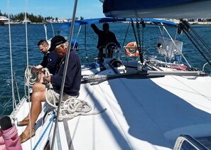 A sailboat with a crew, a lifebuoy, and ropes on deck. - All Included!!Private 3bedSailboat IncludingAccommodations&AllExcursions up to 6 (Key West)